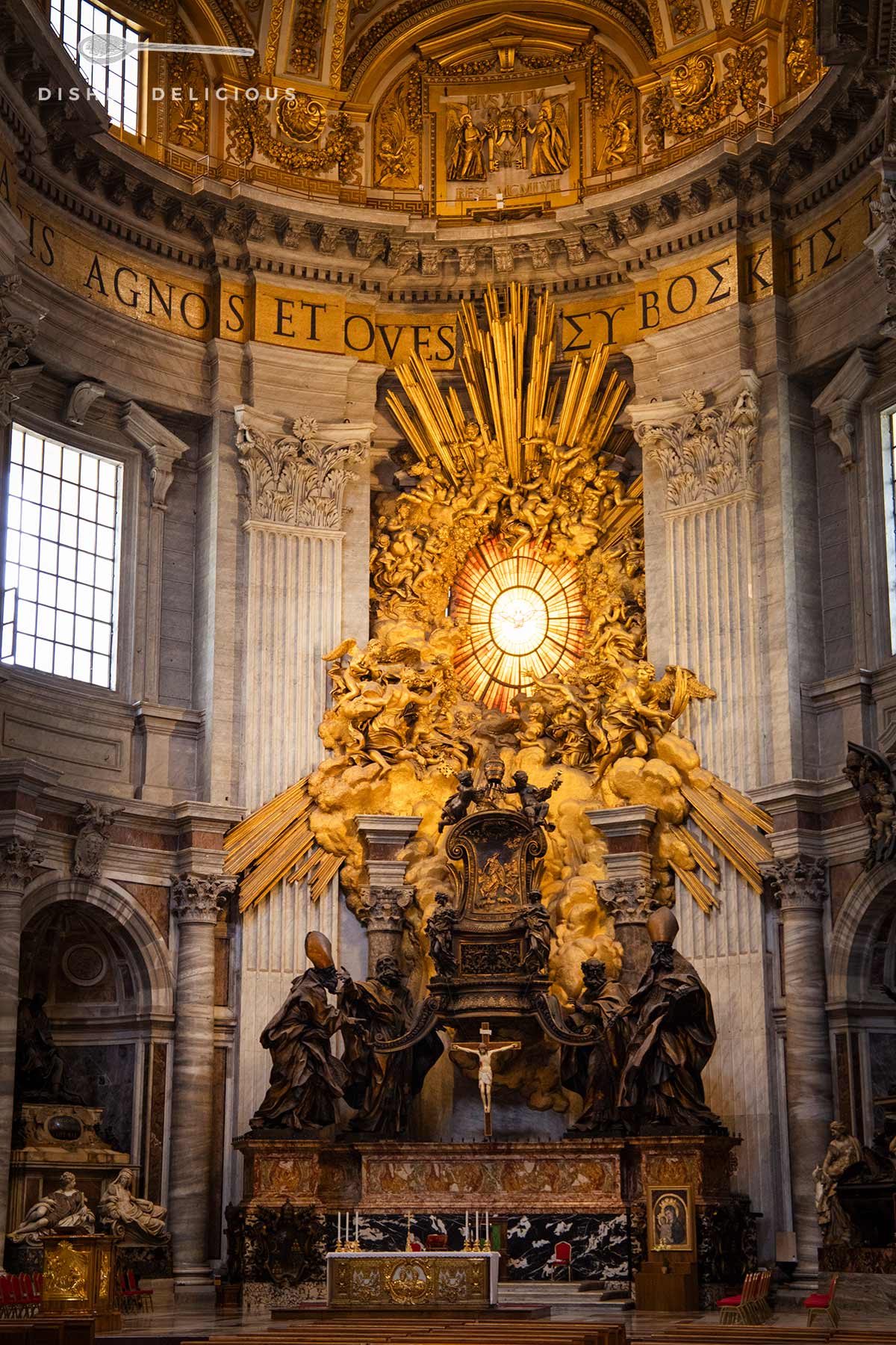 Sehenswürdigkeit im Petersdom: die Cathedra Petri, ein monumentaler Altar umrahmt von goldenen Strahlen, die das Licht aus einer kunstvollen Sonnenrose reflektieren.