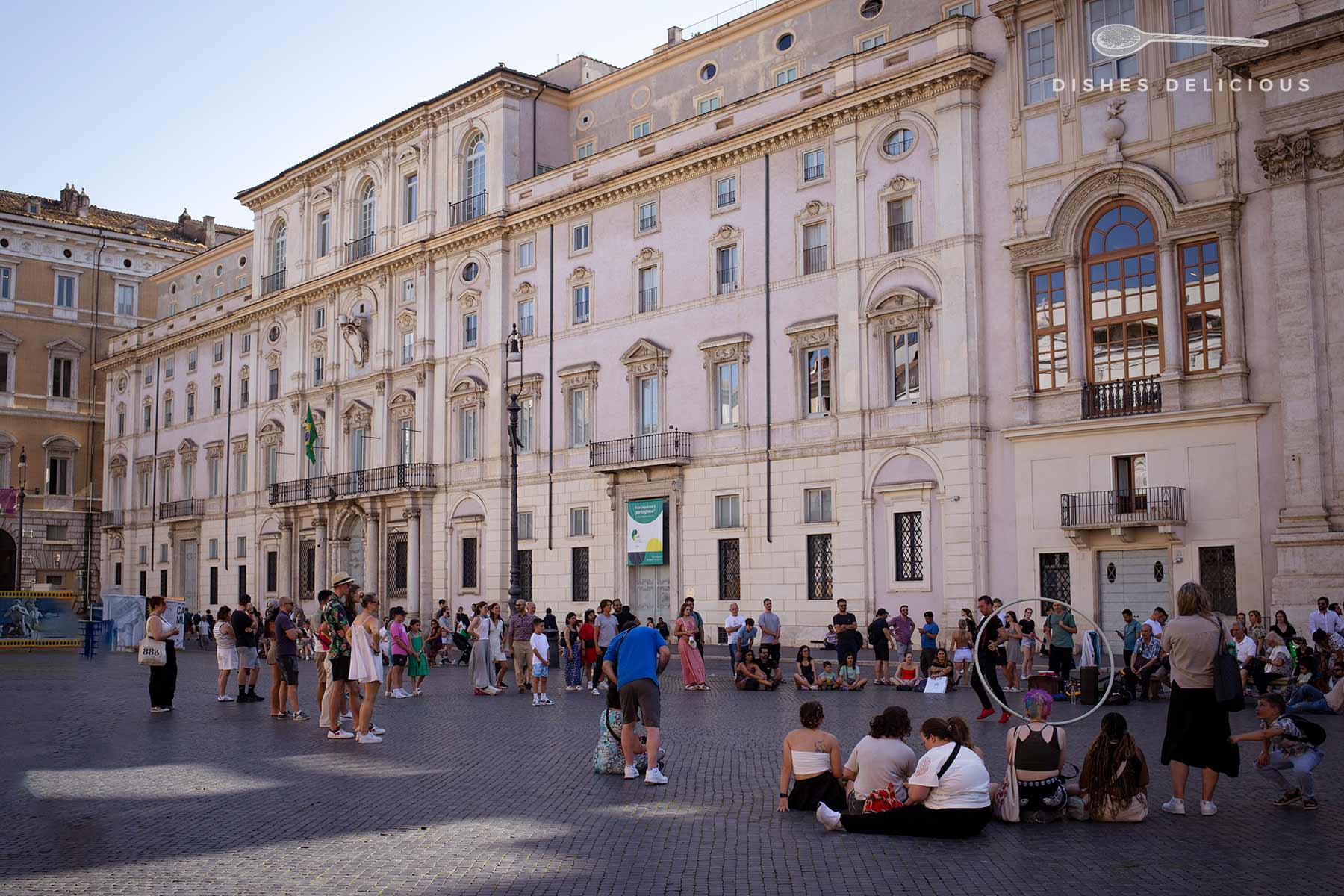 Ein Straßenkünstler zeigt Kunststücke vor Passanten auf der Piazza Navona.