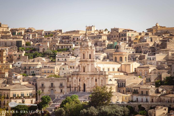 Der Dom San Giorgio in Modica mit breiter Freitreppe. Die Sehenswürdigkeit ist umringt von den Häusen der Altstadt.