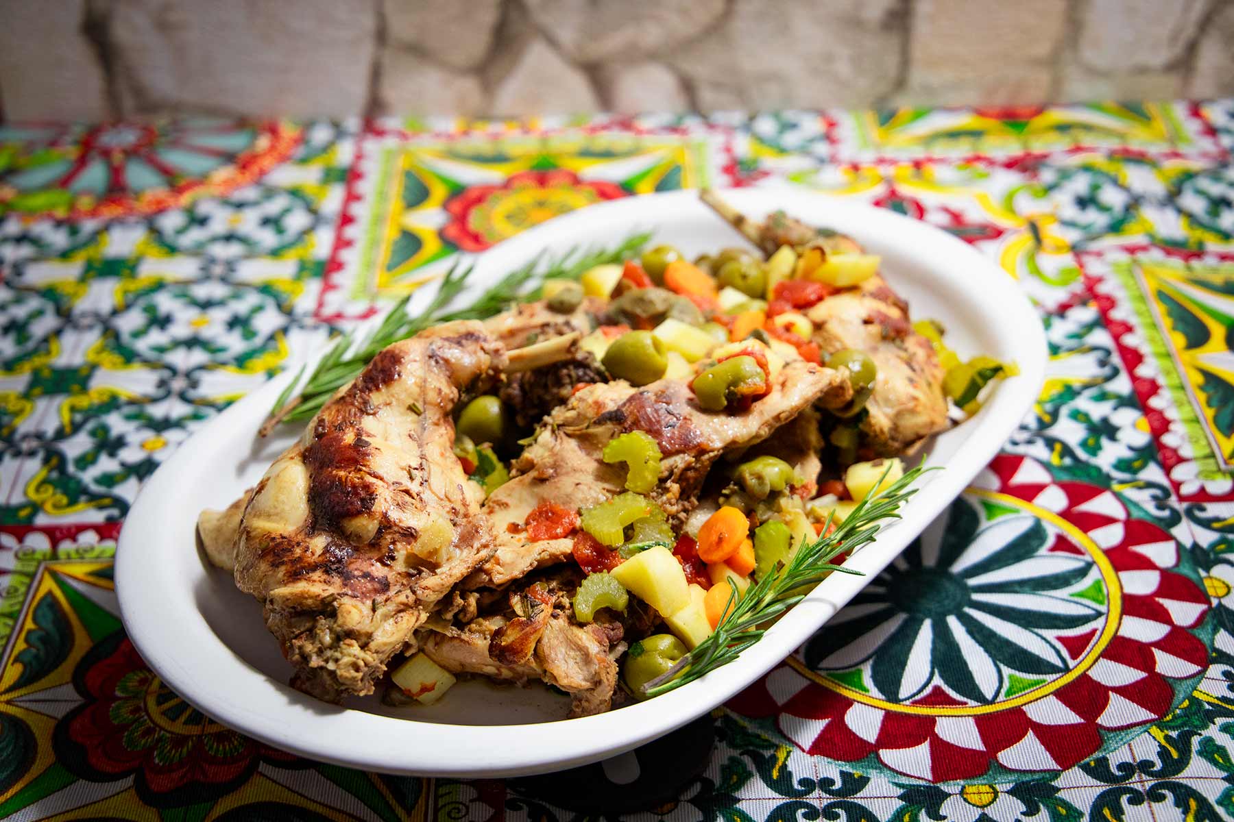Ein Servierteller mit Kaninchenfleisch auf Ragusa-Art mit Gemüse.