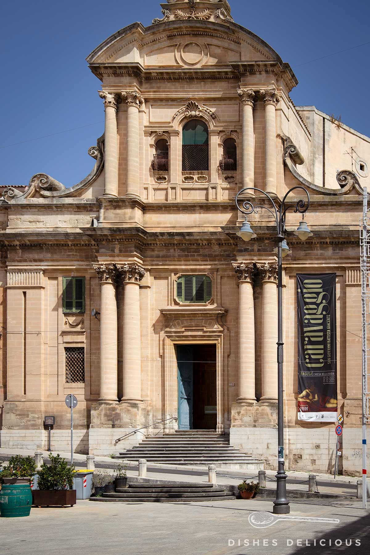 Die zweistöckige Barockkirche Chiesa della Badia, deren Fassade von massiven Säulen geprägt ist.