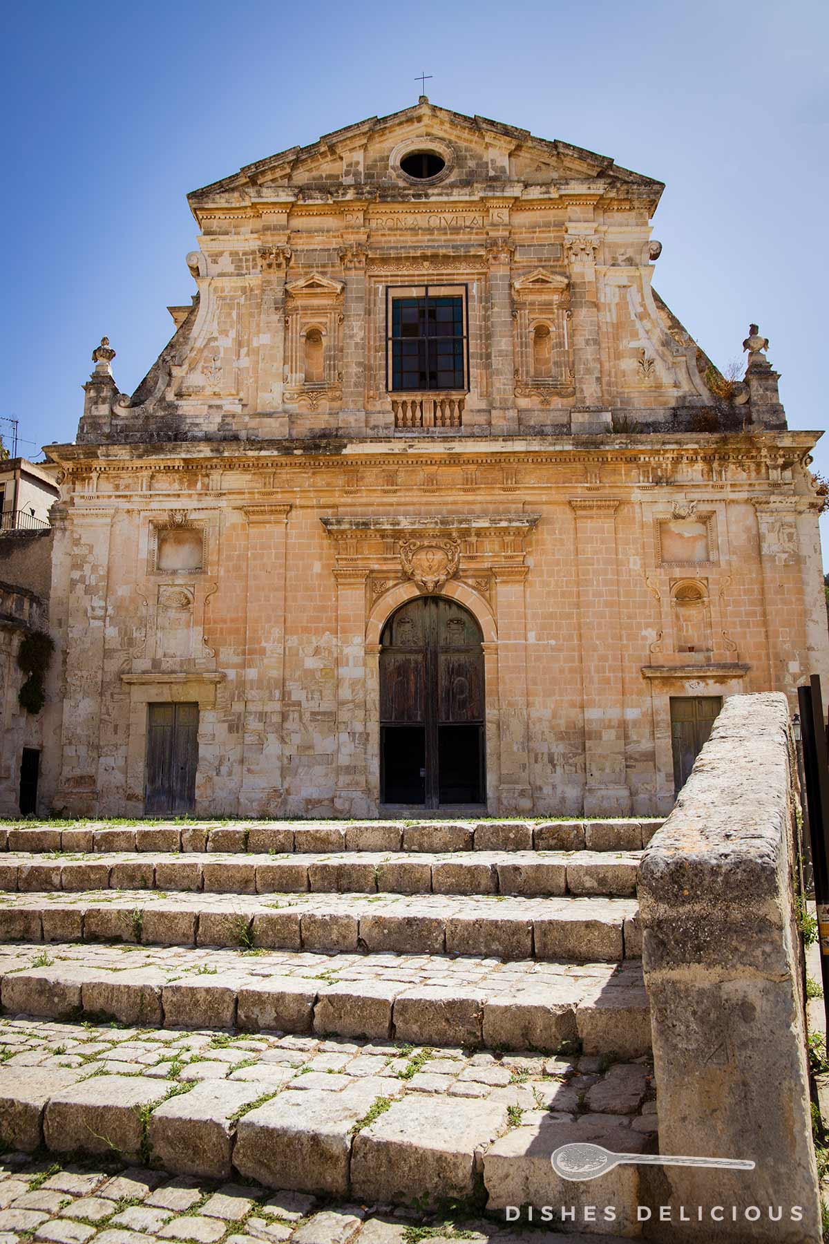 Fassade der barocken Kirche Chiesa Consolazione in Scicli mit steinernen Stufen im Vordergrund
