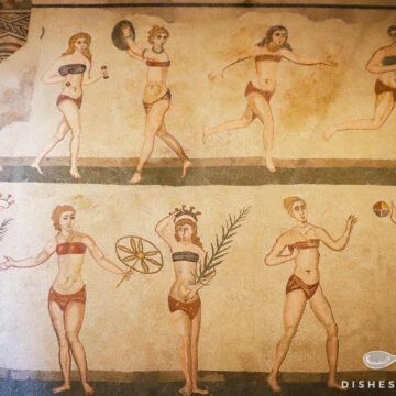 Antike Mosaikdarstellung von Frauen in Bikinis bei sportlichen Aktivitäten in der Villa Romana del Casale.