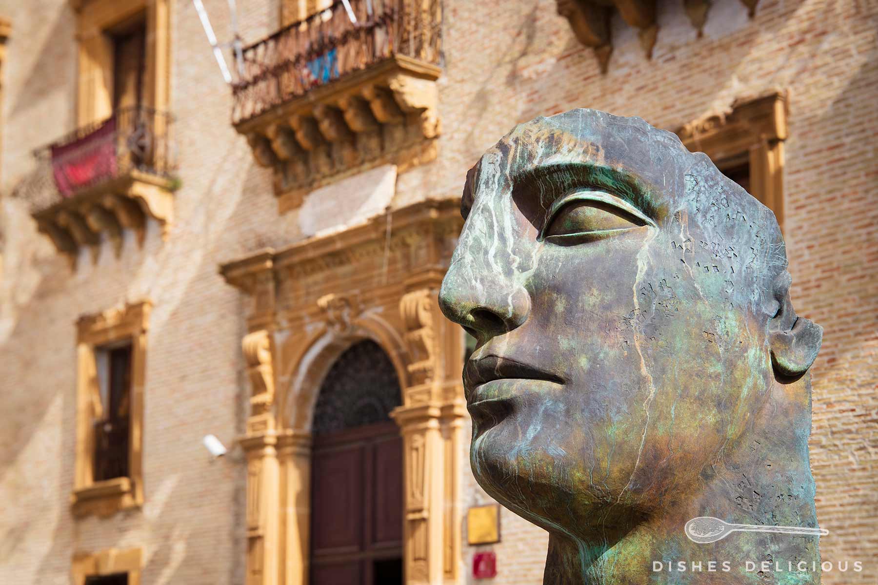 Bronzestatue eines Kopfes vor dem historischen Palazzo Trigona in Piazza Armerina, Sizilien.