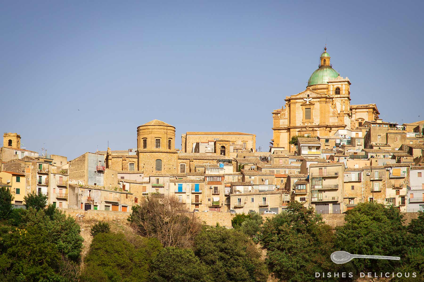 Blick auf die historische Stadt Piazza Armerina in Sizilien mit der markanten Kuppel der Kathedrale und Häusern auf einem Hügel.