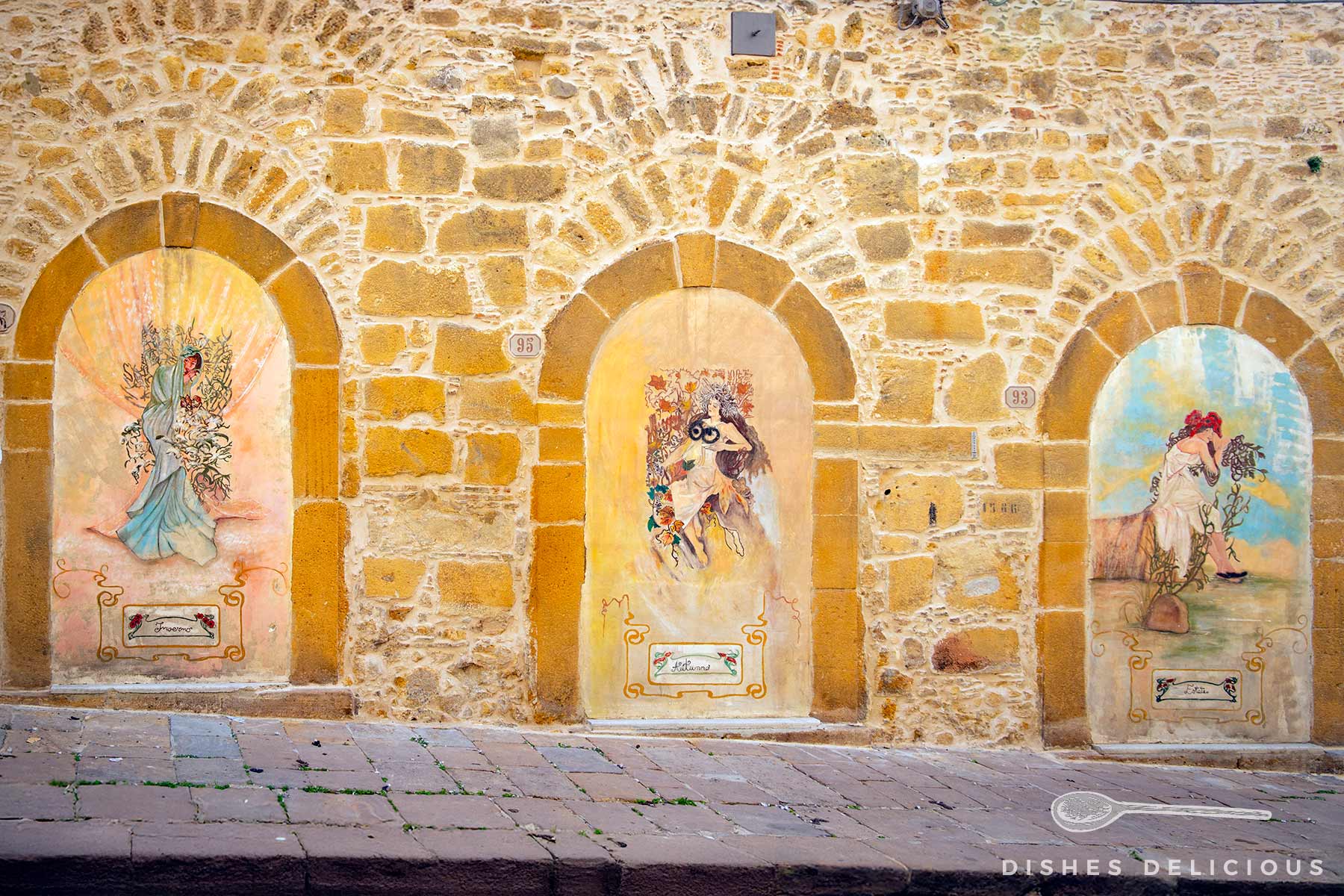 Drei Wandgemälde in Rundbögen einer Steinmauer in der Via Umberto, Piazza Armerina, mit verschiedenen Figuren und Szenen.