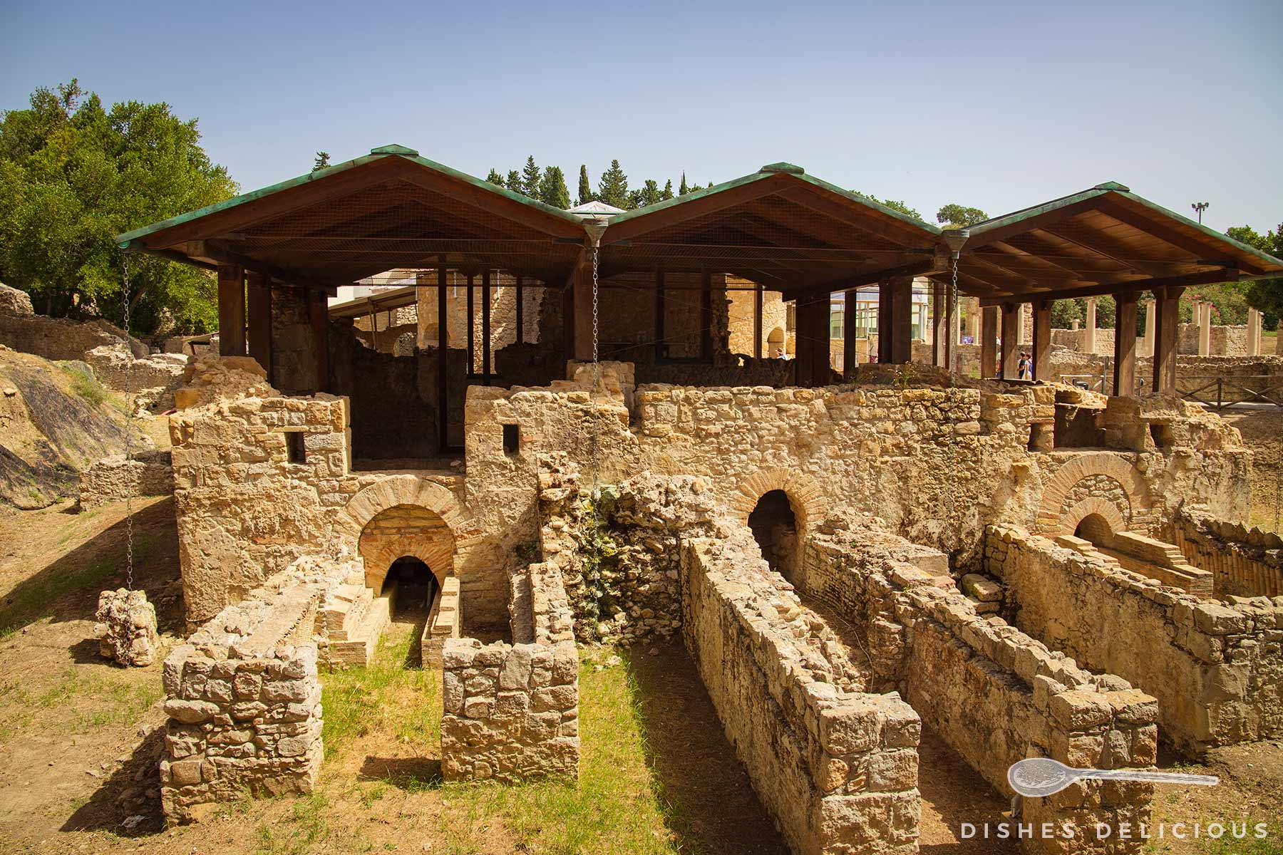 Ruinen der Villa Casale in Piazza Armerina, Sizilien, mit überdachten antiken Steinmauern und Bögen.