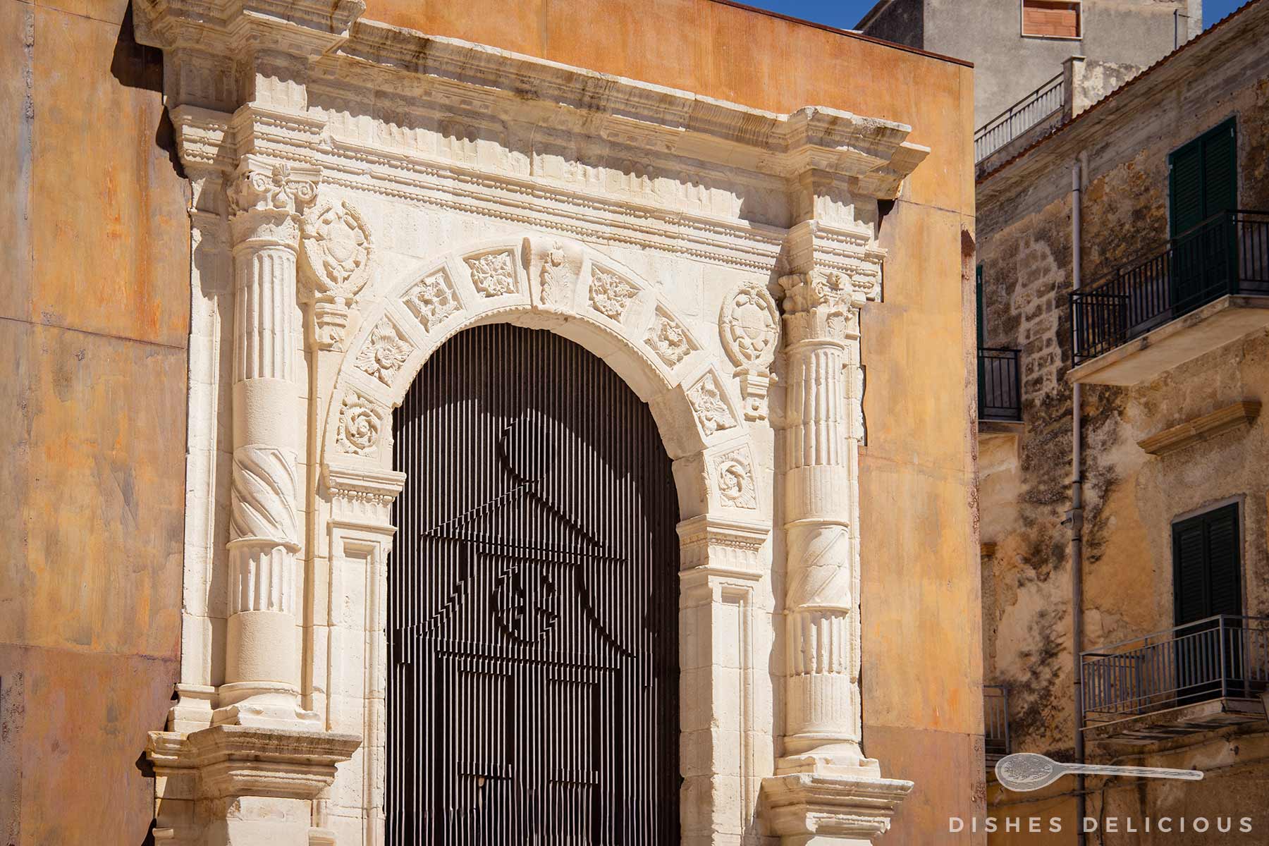 Steinernes Portal der Kirchenruine San Giorgio mit verzierten Säulen und Rundbogen.