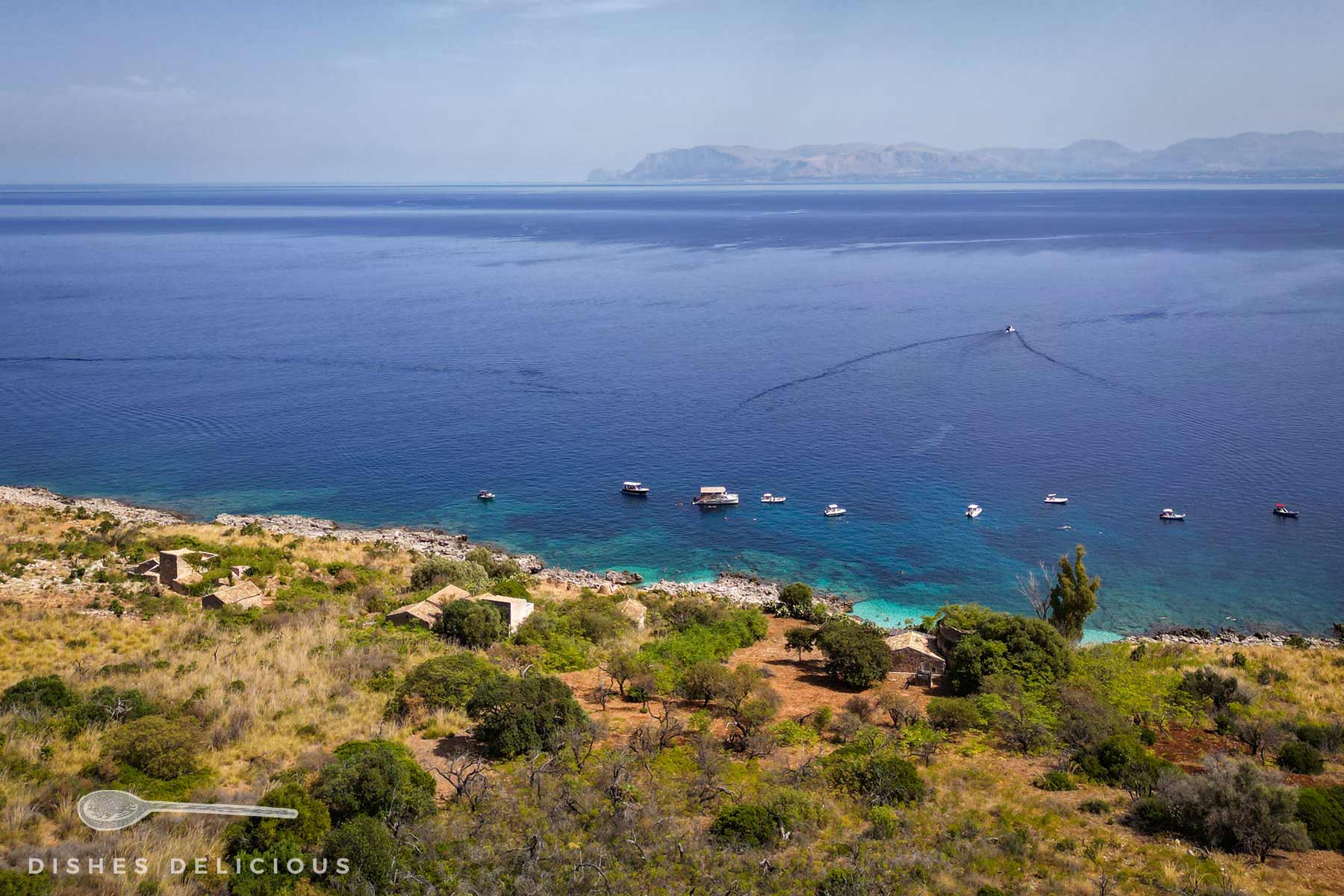 Blick auf die Küste und das Meer mit vereinzelten Booten im Naturpark Lo Zingaro.